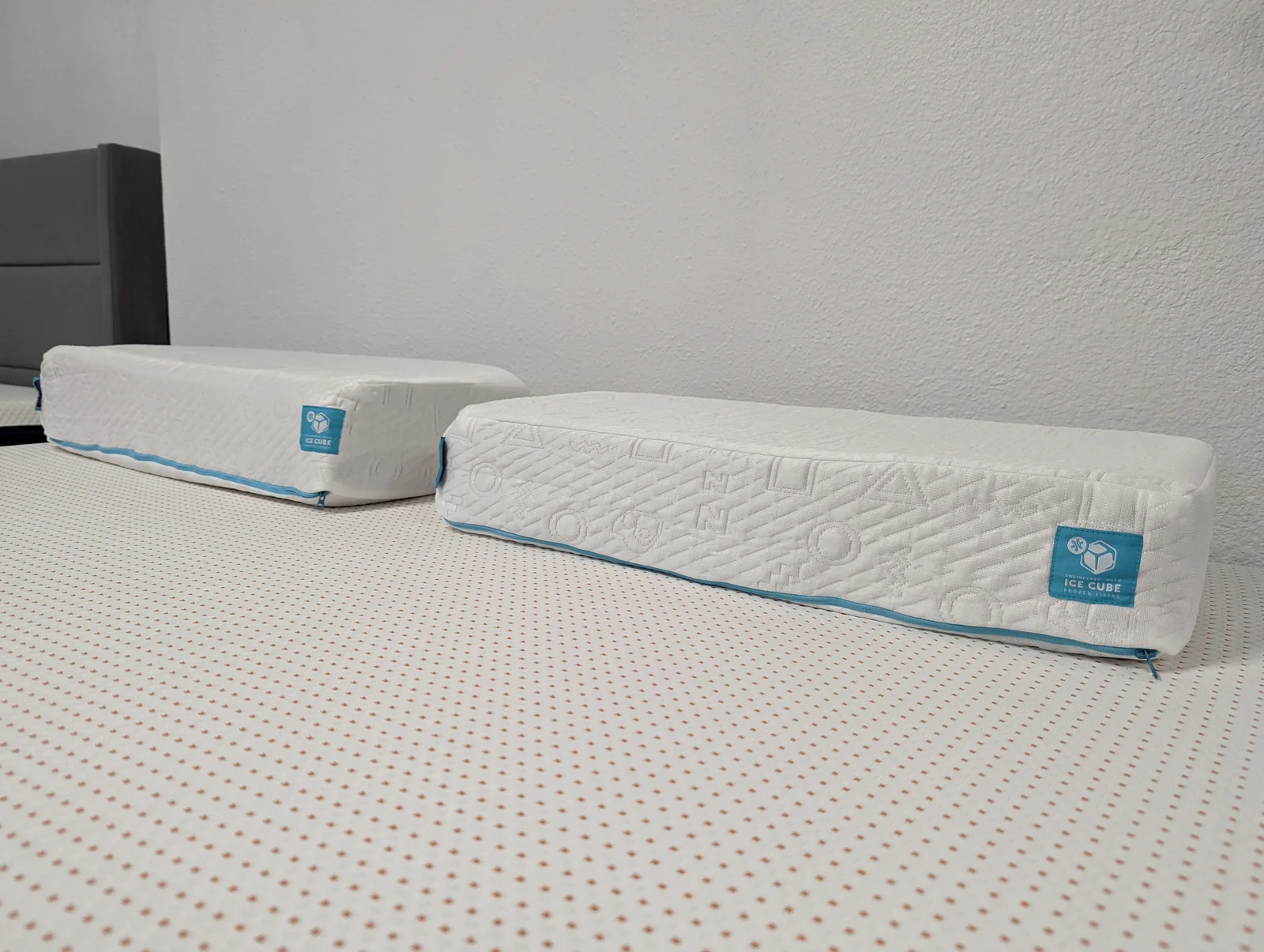 Archival photo showing two Pillow Cube Ice Cube pillows side by side on a mattress